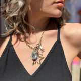 A woman wearing the Gypsy Star 20" Necklace with a black top.