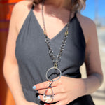 A woman wearing the Gorgeous Gunmetal Crystal 32" Necklace with a black dress.