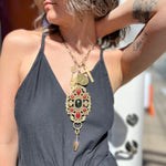 A woman wearing the Gypsy Junk Luxe-A 24" Length Necklace with a black dress.