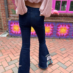 A woman wearing the Dark Denim Bellbottoms with Embroidery Detail.