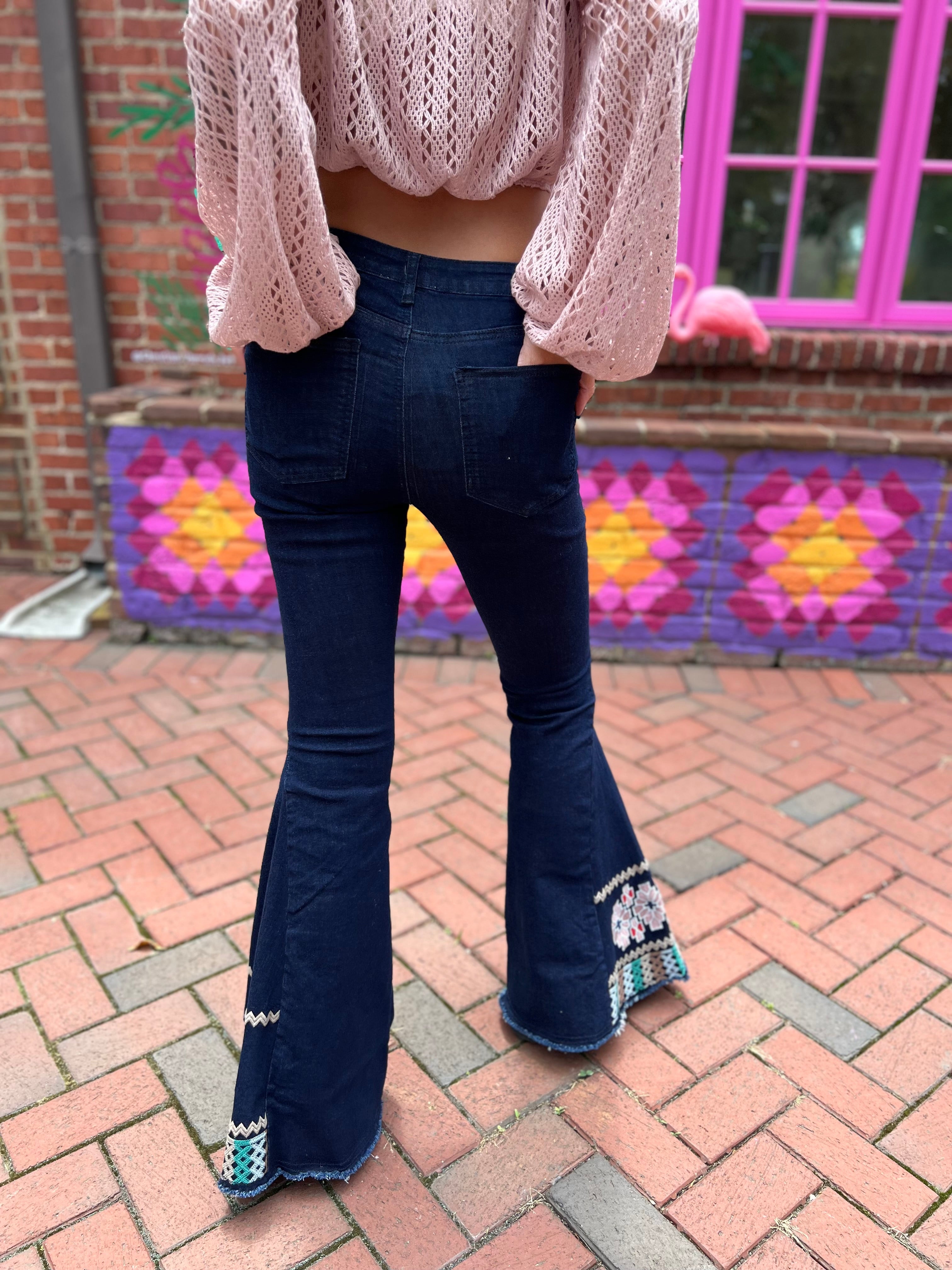A woman wearing the Dark Denim Bellbottoms with Embroidery Detail.