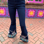 A woman wearing the Dark Denim Bellbottoms with Embroidery Detail.