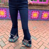 A woman wearing the Dark Denim Bellbottoms with Embroidery Detail.