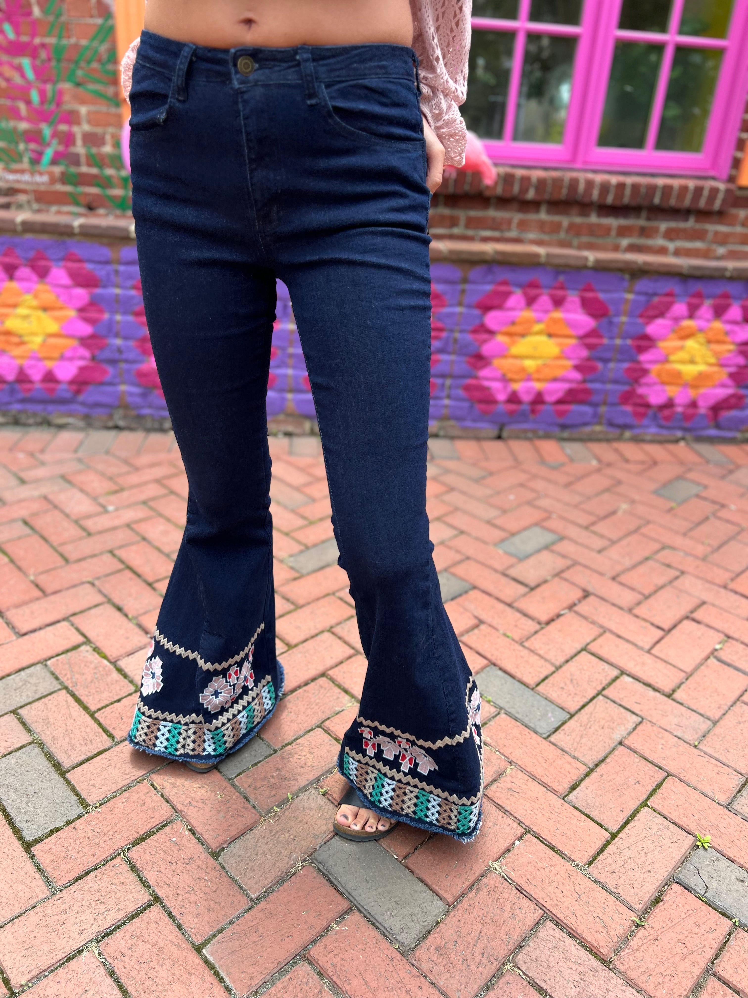 A woman wearing the Dark Denim Bellbottoms with Embroidery Detail.