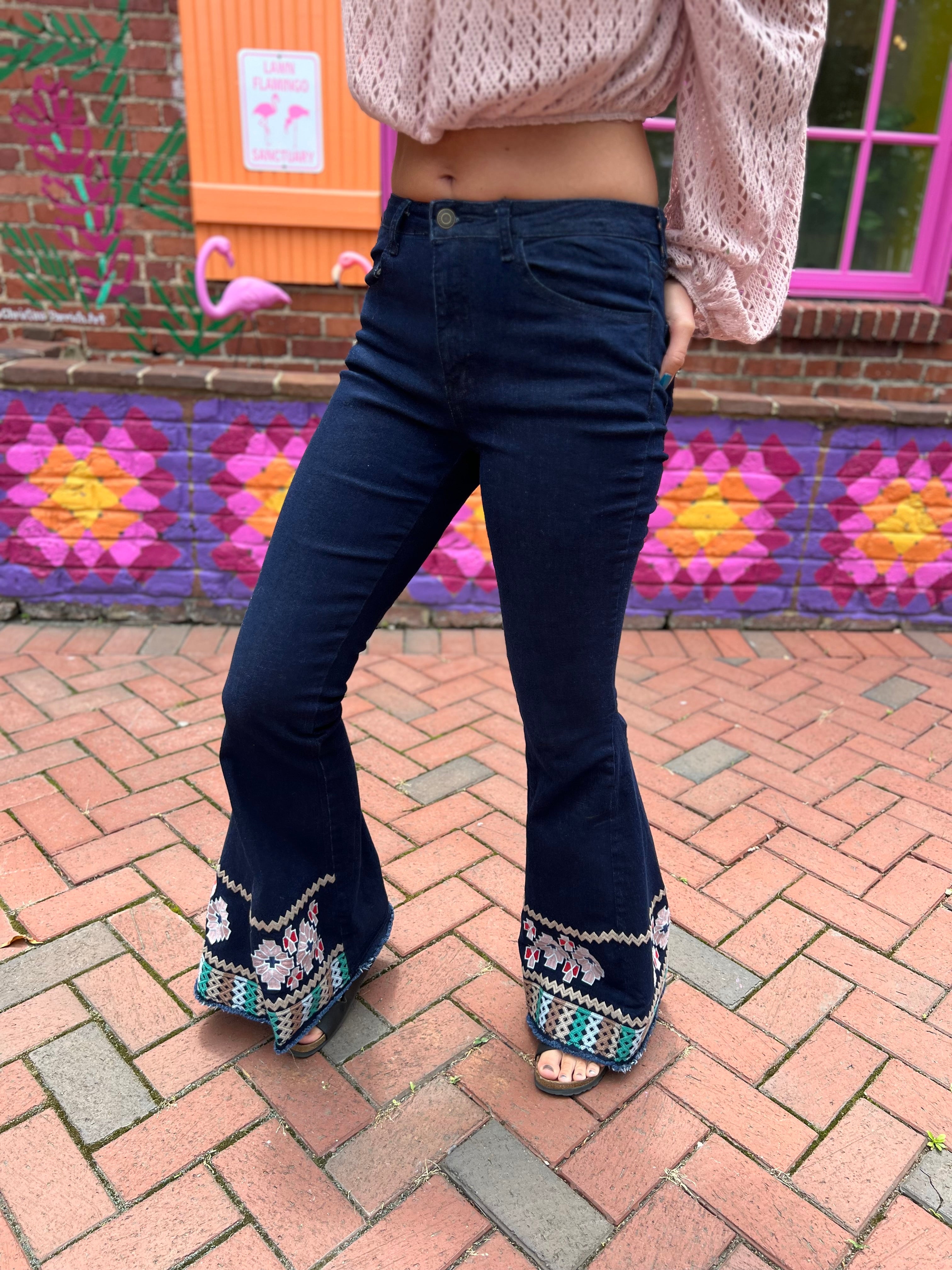 A woman wearing the Dark Denim Bellbottoms with Embroidery Detail.