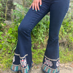 A woman wearing the Dark Denim Bellbottoms with Embroidery Detail.