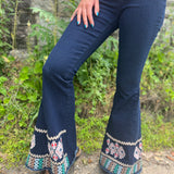 A woman wearing the Dark Denim Bellbottoms with Embroidery Detail.
