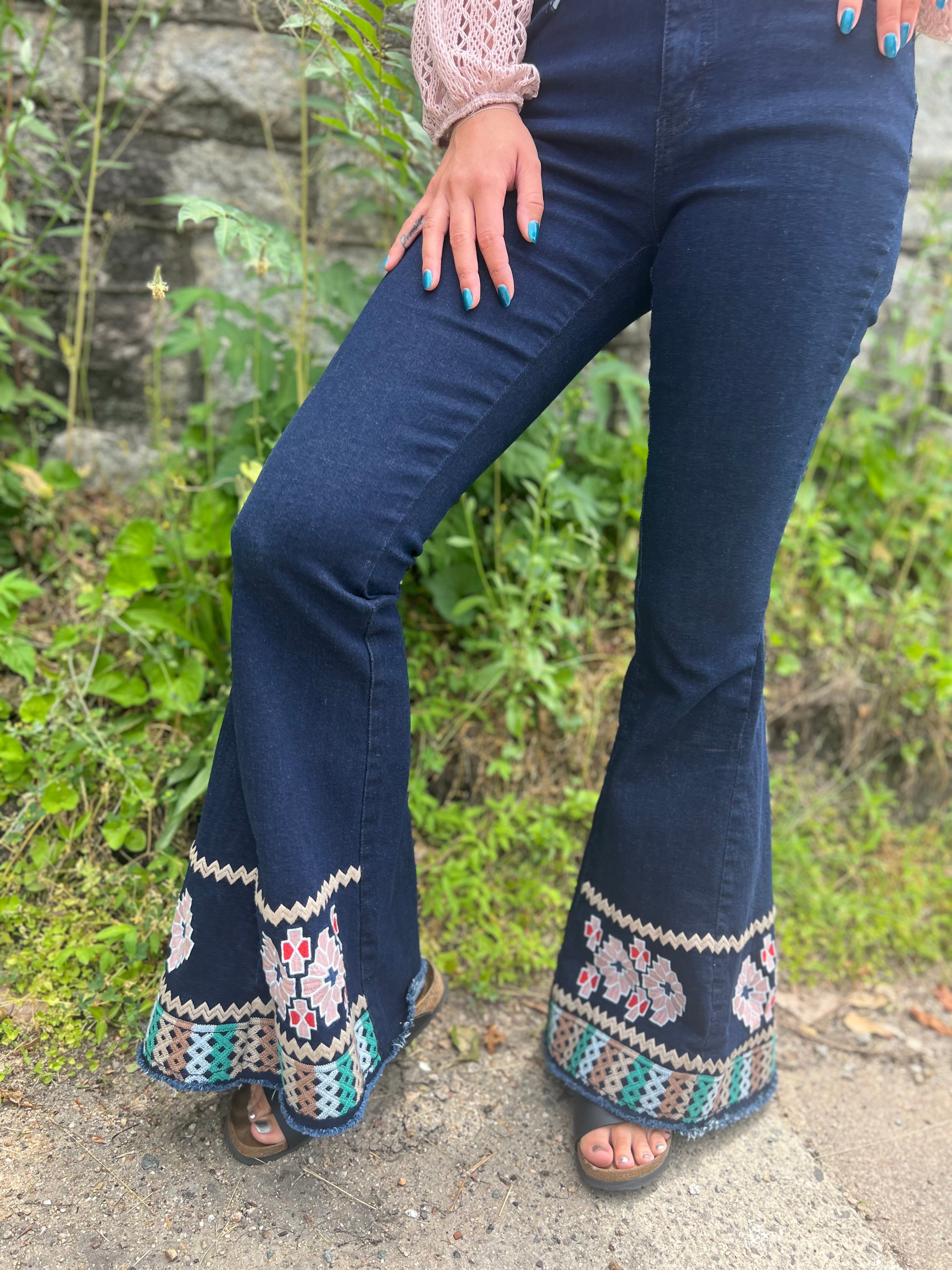 A woman wearing the Dark Denim Bellbottoms with Embroidery Detail.
