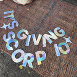 The It's Giving Scorpio Banner Iridescent Foil Banner on a rug.