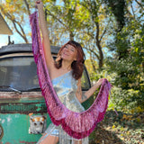 A woman holding the Tickled Pink Scalloped Layered Fringe Banner in front of a vintage teal Volkswagen bus.