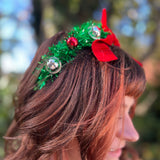 A woman wearing the Oh Christmas Fringe & Bow Headband with a silver dress.