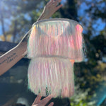A woman holding the Iridescent Fringe Party Chandelier.