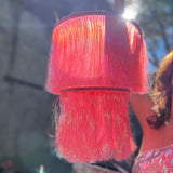 A woman holding the Iridescent Pink Fringe Party Chandelier.