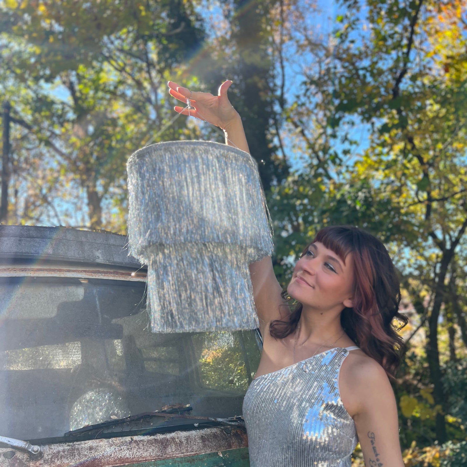 Someone holding the Disco Party Chandelier in front of a vintage teal Volkswagen bus.