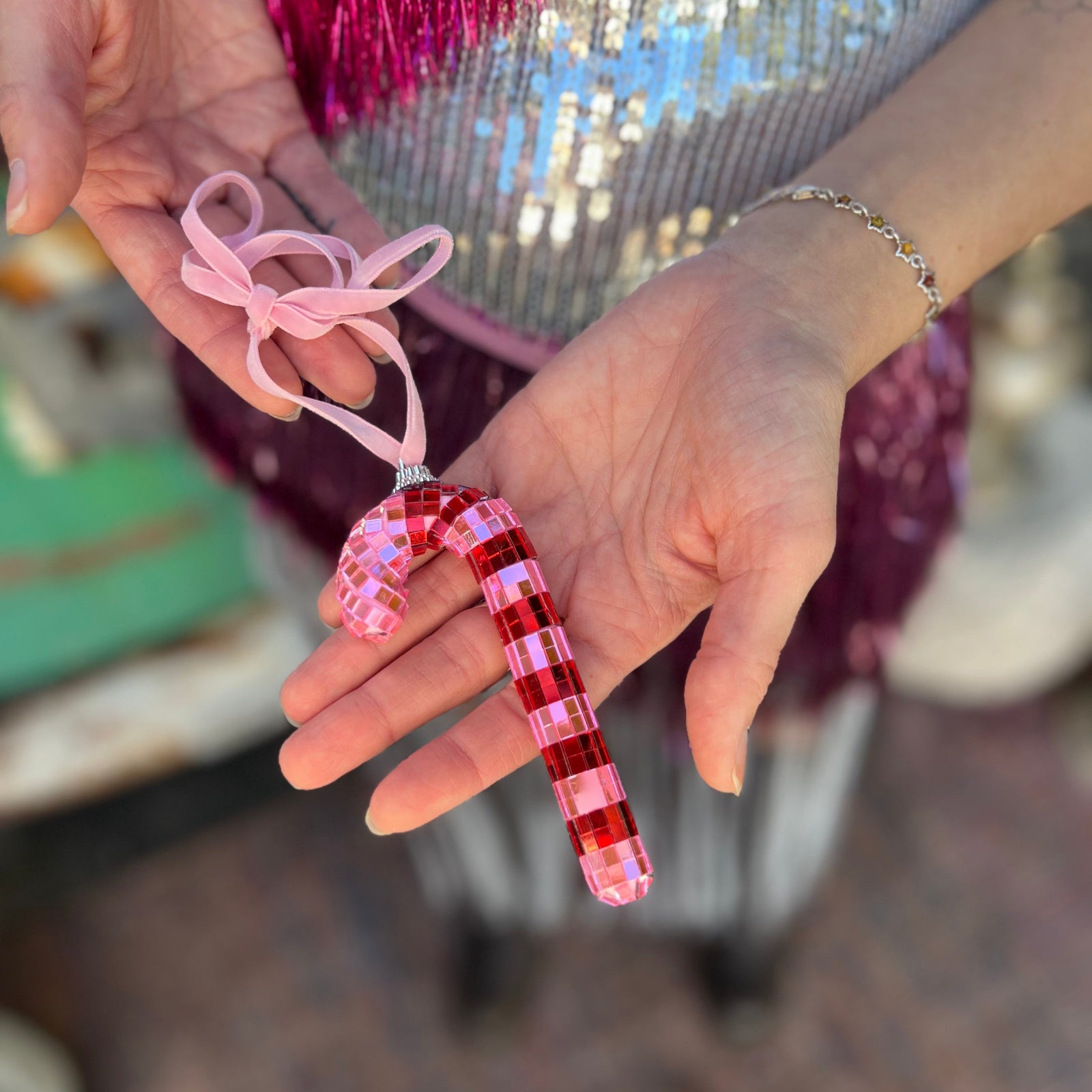 Someone holding the Disco Candy Cane Ornament.