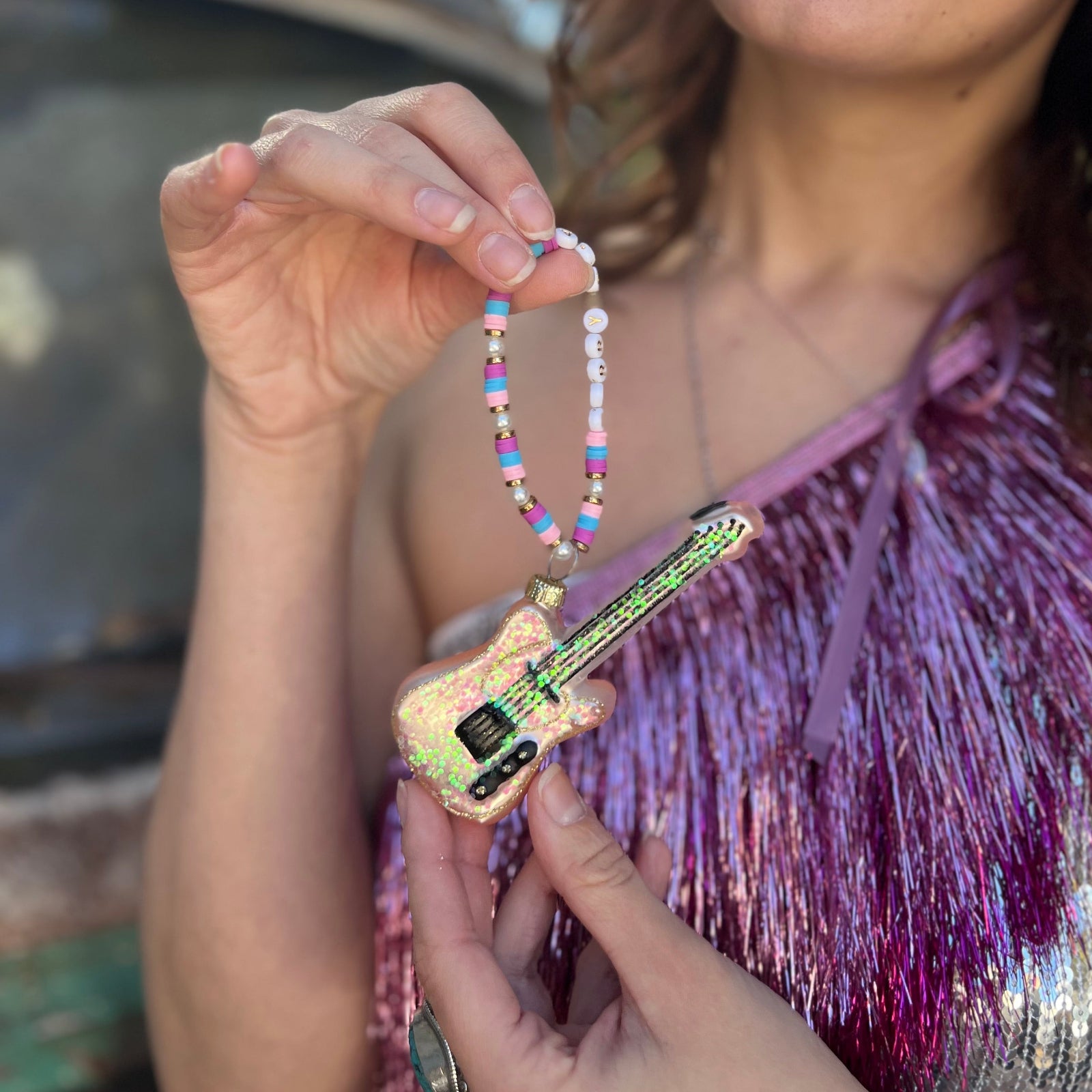 Someone holding the Merry Era Friendship Bracelet Ornament.