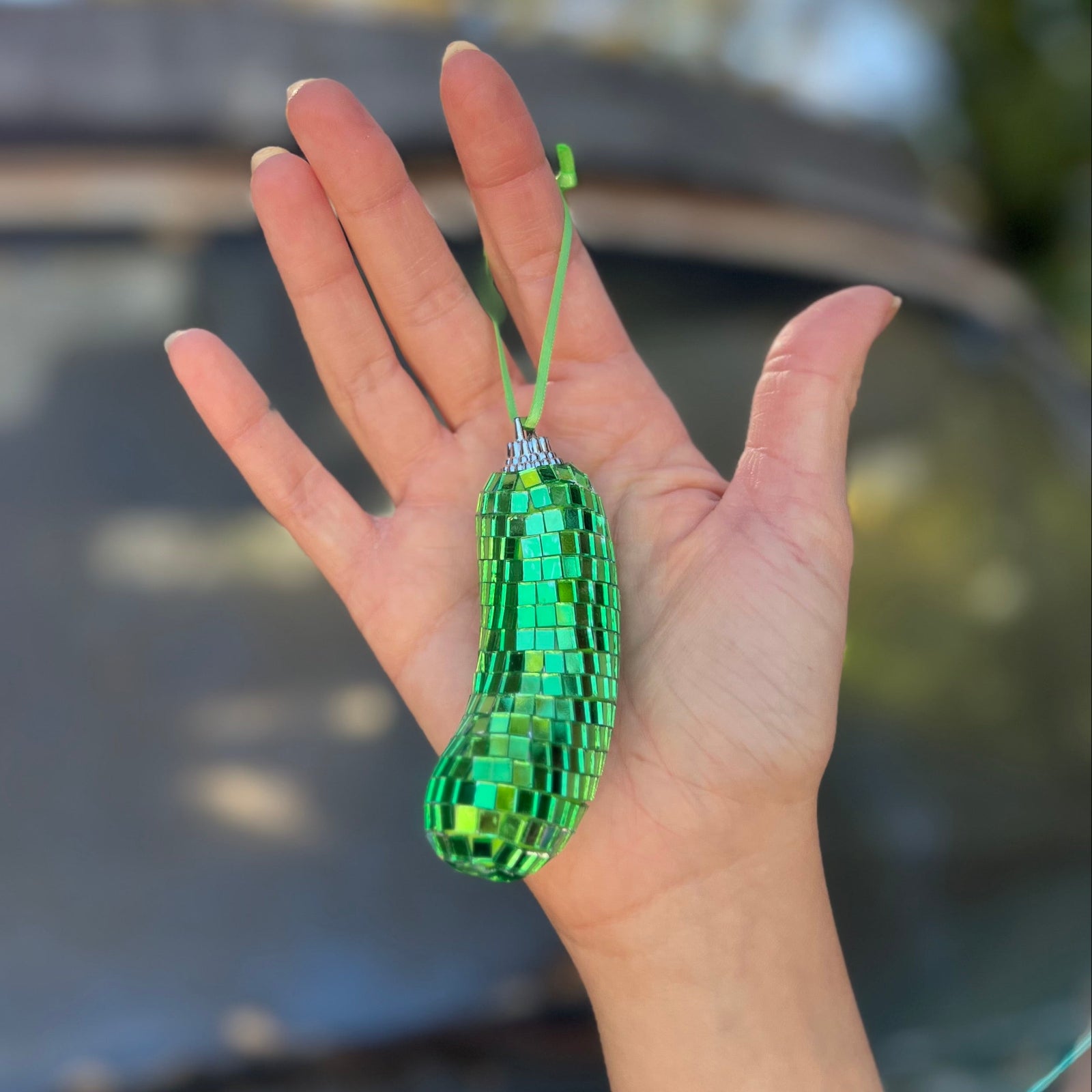 Someone holding the Disco Pickle Ornament.