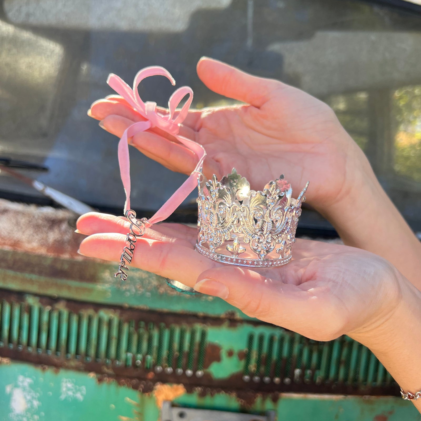 Someone holding the Glinda inspired ornament from the Emerald City 2 Piece Ornament Set.