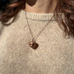 A woman wearing the Real Copper Acorn Necklace with a beige sweater.