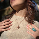 A woman wearing the Real Copper Acorn Necklace with a beige sweater.