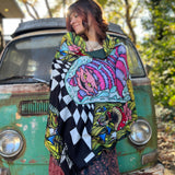 A woman wrapped up in the Cheshire Inspired Pashmina in front of a vintage teal Volkswagen bus.