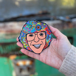 Someone holding the Phil Lesh Grateful Dead Patch in front of a vintage teal Volkswagen bus.