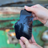 Someone holding the Palm Reader Iron-On Patch - Hippie Bohemian Embellishment in front of a vintage teal Volkswagen bus, showing off the back.