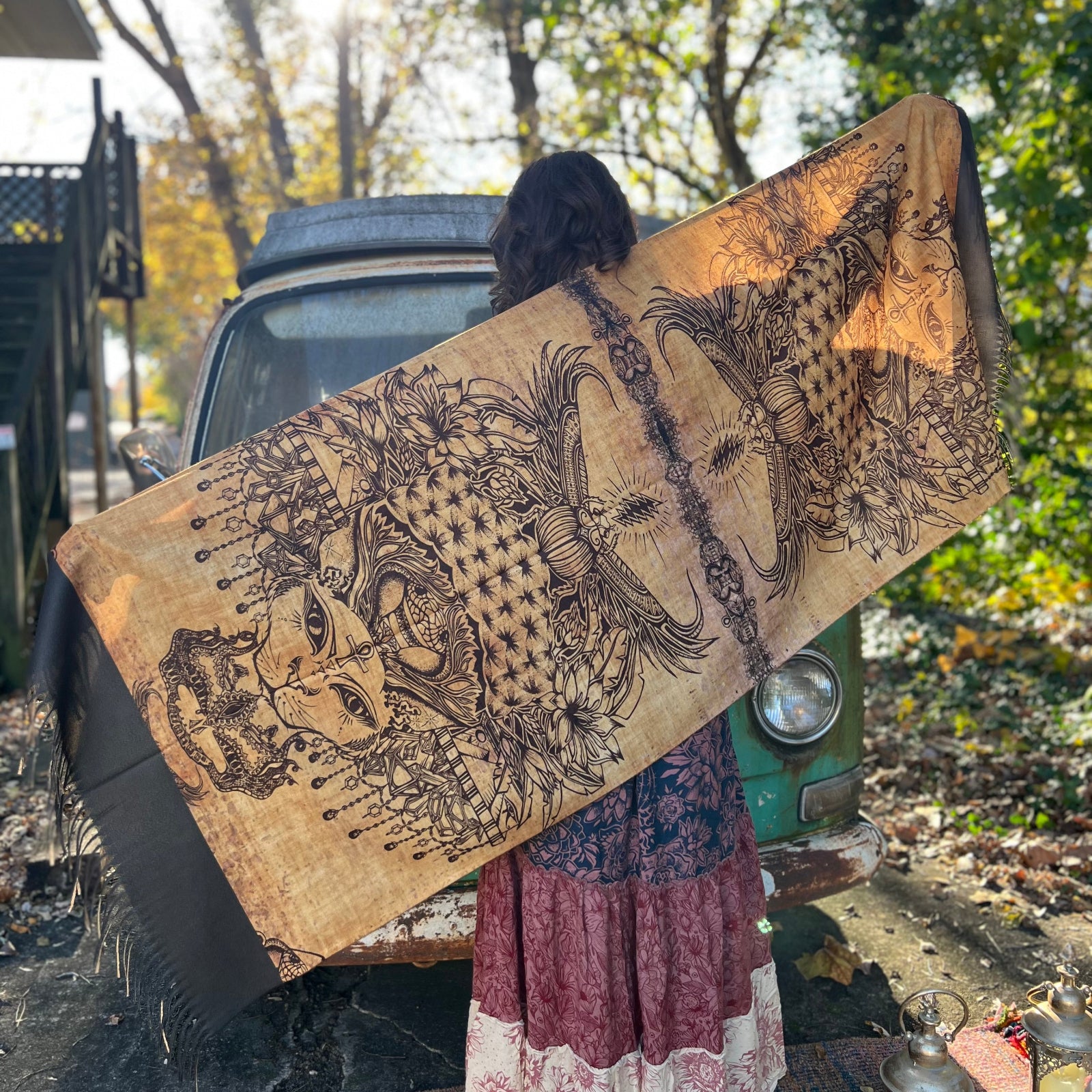 A woman holding the Cats Under The Stars Pashmina out showing off the entire design.