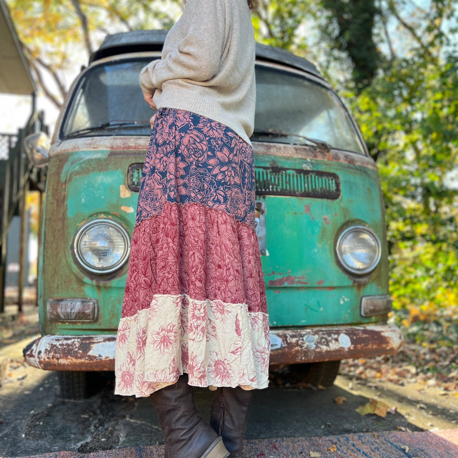 Someone wearing the  witCactus Garden Tiered Maxi Skirt a beige skirt in front of a vintage Volkswagen bus, showing off the side.