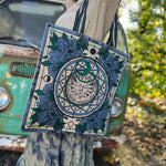 A woman wearing the Sun Bandana Blue Canvas Tote Bag with a skirt and a tan sweater.