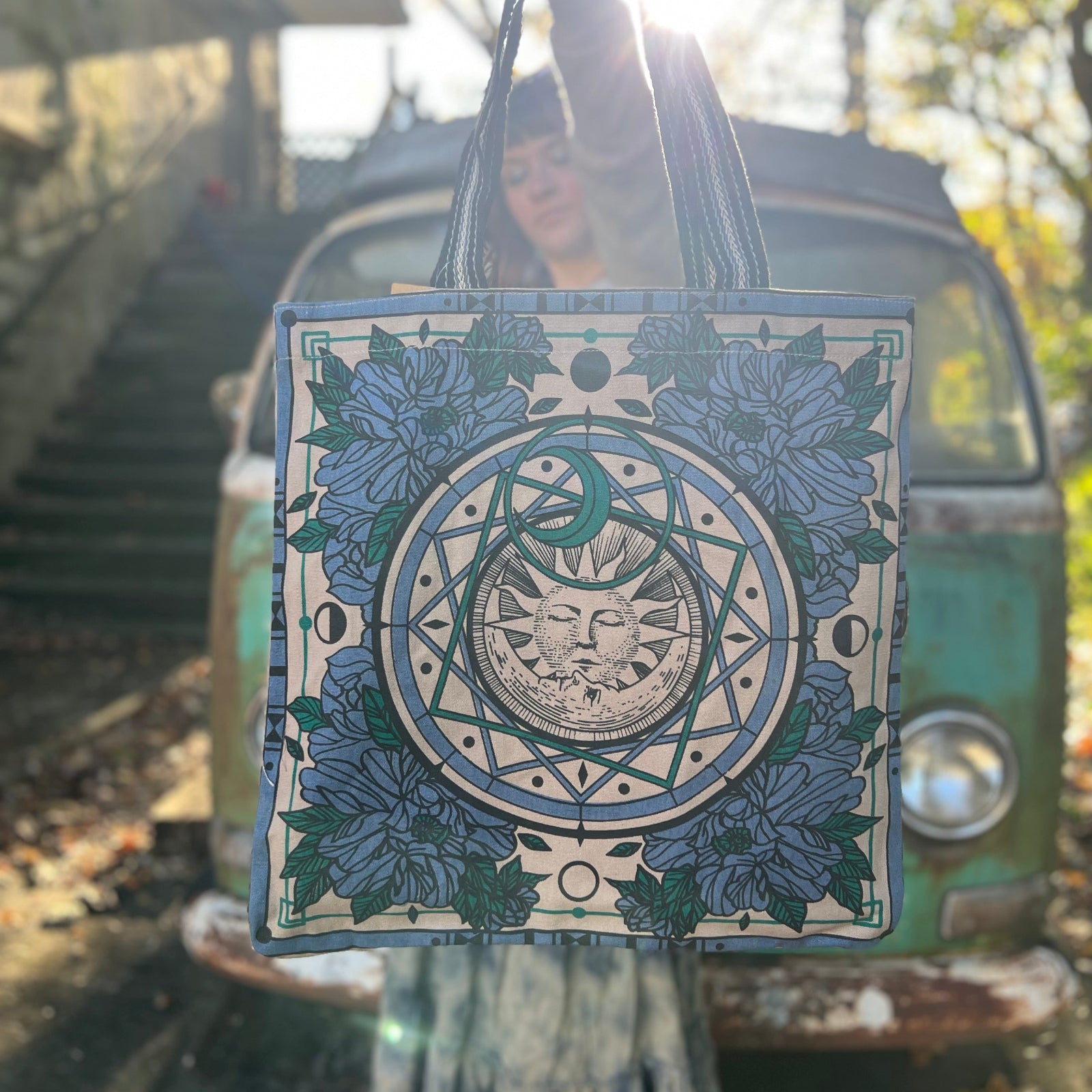 Someone holding a Sun Bandana Blue Canvas Tote Bag in front of themselves.