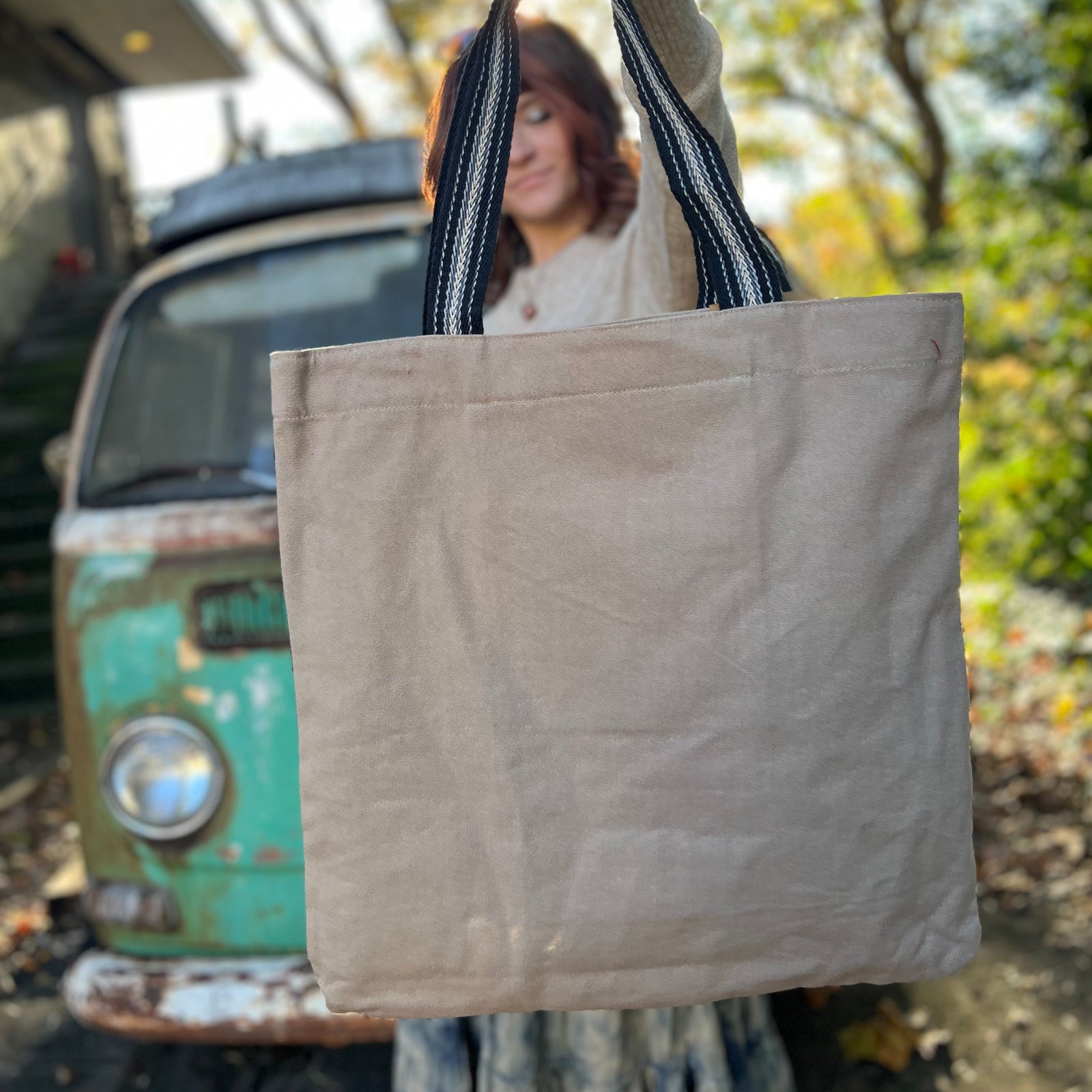 Someone holding a Sun Bandana Blue Canvas Tote Bag in front of themselves, showing off the back.
