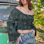 A woman wearing the forest Flowy Peasant Viscose Print Blouse with a skirt in front of the vintage teal Volkswagen bus.