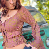 A woman wearing the maroon Flowy Peasant Viscose Print Blouse with a skirt in front of the vintage teal Volkswagen bus.
