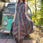 A woman wearing the olive Striped Twirl Skirt Cotton Overall with brown boots in front of a vintage teal Volkswagen bus.
