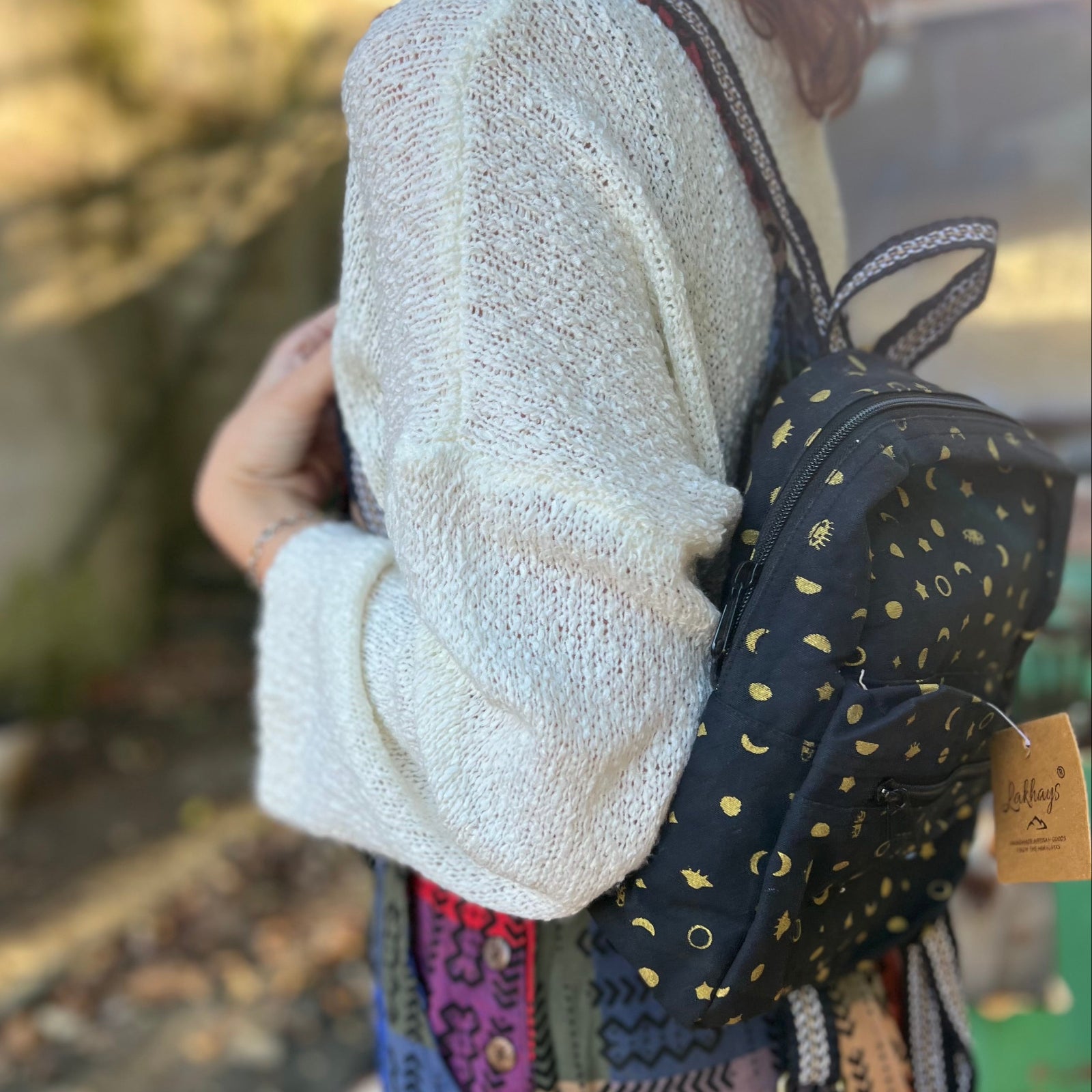 A woman wearing the Tiny Moon Celestial Backpack in front of themselves.