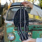 Someone holding the Tiny Moon Celestial Backpack in front of a vintage teal Volkswagen bus, showing off the back.