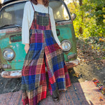 A woman wearing the Cotton Plaid Wide Leg Overalls with a white long sleeve in front of a vintage teal Volkswagen bus.