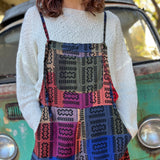 A woman wearing the Cotton Plaid Wide Leg Overalls with a white long sleeve in front of a vintage teal Volkswagen bus.