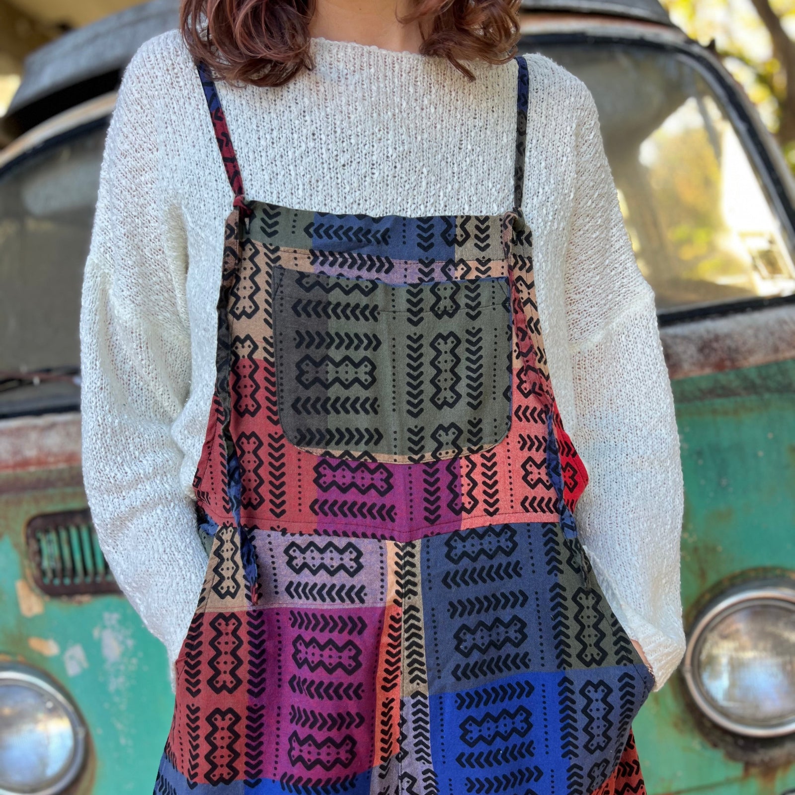 A woman wearing the Cotton Plaid Wide Leg Overalls with a white long sleeve in front of a vintage teal Volkswagen bus.