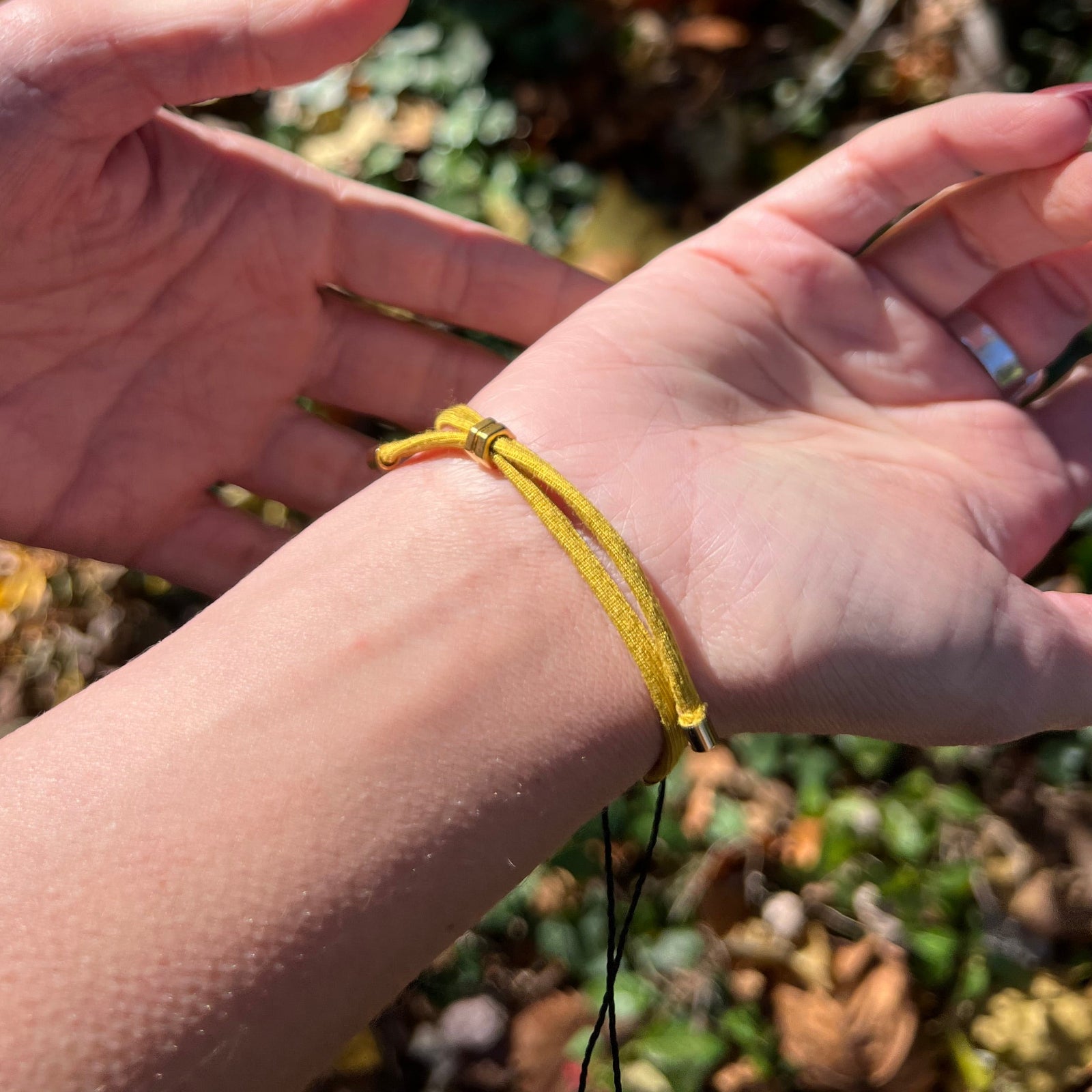 Someone wearing the Adjustable Gold & Pink Evil Eye Protection Bracelet.