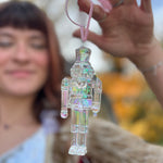 Someone holding the Iridescent Nutcracker Holiday Ornament in front of them.
