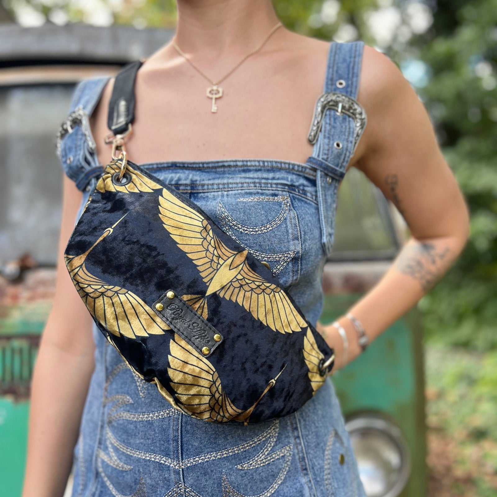 Someone wearing the Black And Gold Heron Fanny Bag with a denim romper.