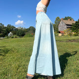 A woman wearing the light wash Denim Drawstring Waist Band Wide Leg Pants with a cream crocheted top.
