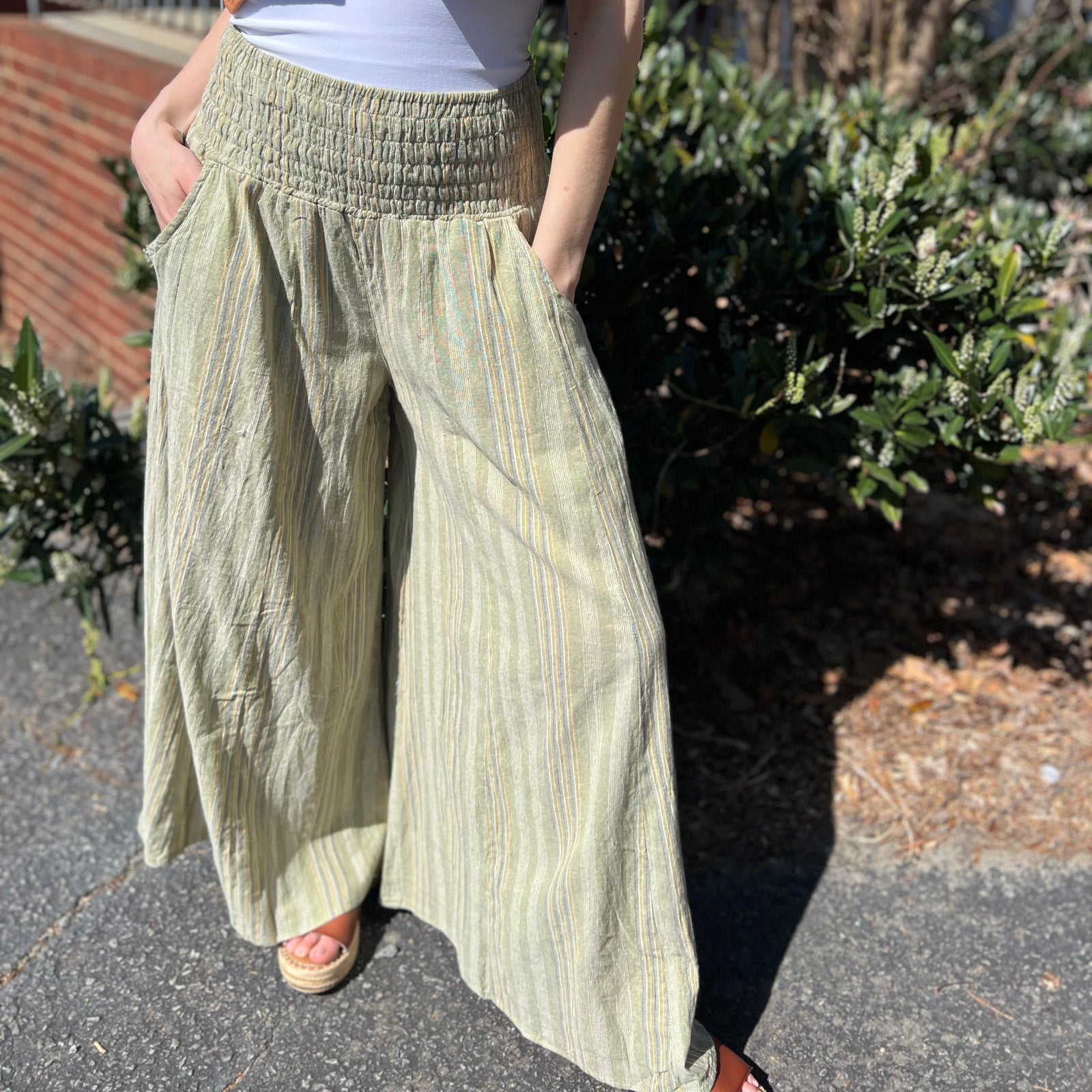 A woman wearing the sage Striped Wide Leg Cotton Pants with a white top and sandals.