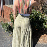 A woman wearing the sage Striped Wide Leg Cotton Pants with a white top and sandals.