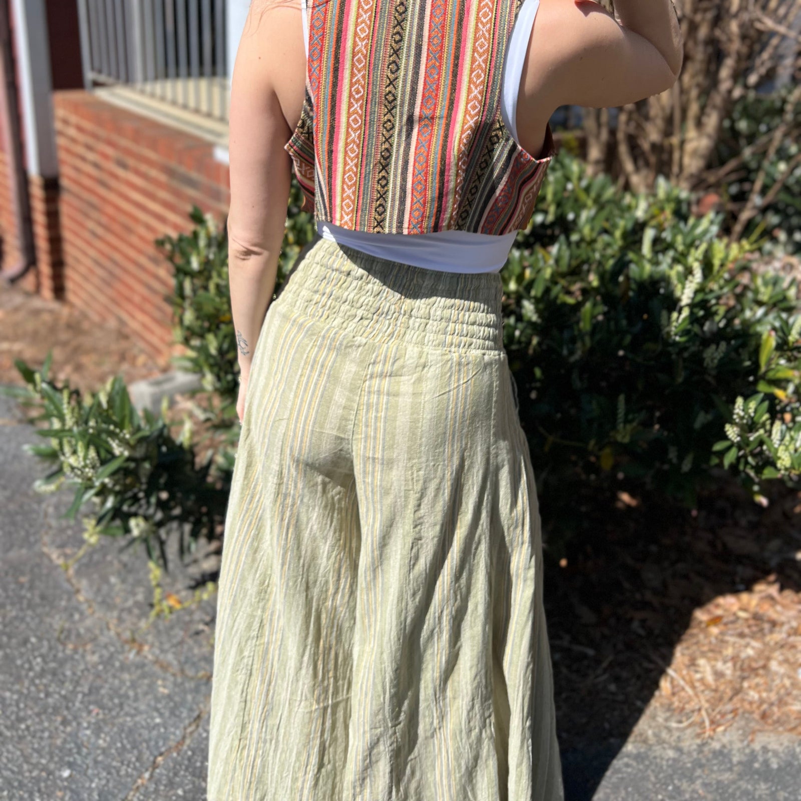 A woman wearing the sage Striped Wide Leg Cotton Pants with a white top and sandals.