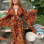 Someone wearing the red Hippie Floral Cinch Maxi Ruffle Skirt in front of a Volkswagen bus.