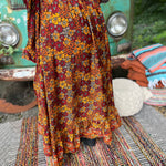 Someone wearing the red Hippie Floral Cinch Maxi Ruffle Skirt in front of a Volkswagen bus.
