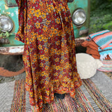 Someone wearing the red Hippie Floral Cinch Maxi Ruffle Skirt in front of a Volkswagen bus.
